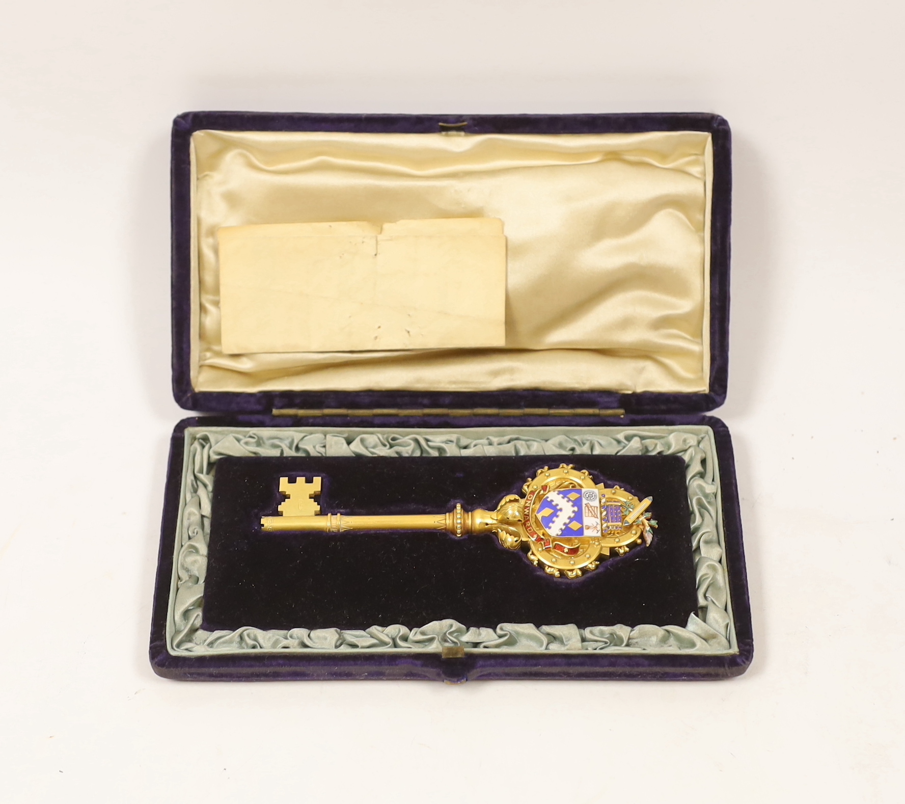 A cased Victorian gilt and polychrome enamelled presentation key, makers mark, M&M, 11.7cm, with engraved inscription relating to the presentation to Mayor Edward Hibbett, on the opening of the Town Hall in Hyde.